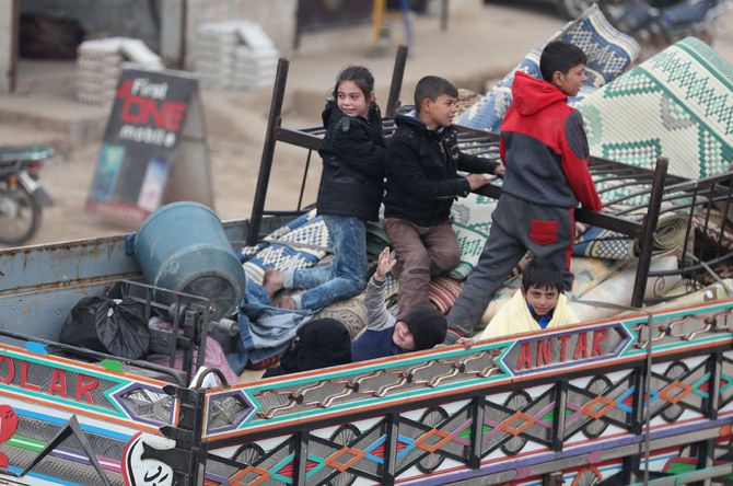 Syrian children sit in the back of a truck transporting their belongings in the northern countryside of Idlib on January 28, 2020, after fleeing its southern countryside as a result of an ongoing offensive by regime forces on Syria's rebel-held northwestern region. (AFP / Omar Haj Kadour)