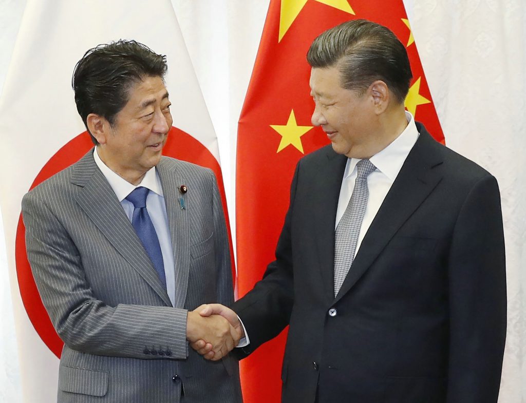 Japan's Prime Minister Shinzo Abe (L) shakes hands with China's President Xi Jinping (R) prior to their bilateral meeting, Vladivostok, Sep. 12, 2018, (AFP)