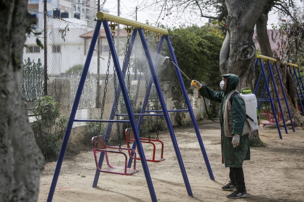 A Palestinian municipal worker sprays disinfectant in the Gaza City Park on March 9, 2020, amid fears of the spread of the novel coronavirus. (AFP)