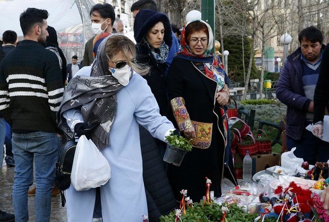 An Iranian woman wearing a protective face mask chooses traditional items ahead of Nowruz, the national New Year 2-week celebration, at the Tajrish Bazaar in the capital Tehran on March 19, 2020. (File/AFP)