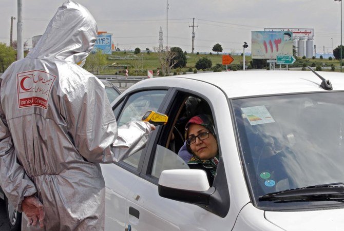 Members of Iranian Red Crescent test people with possible coronavirus symptoms, after Iran slapped a ban on intercity travel to try to curb the spread or the virus. (AFP)