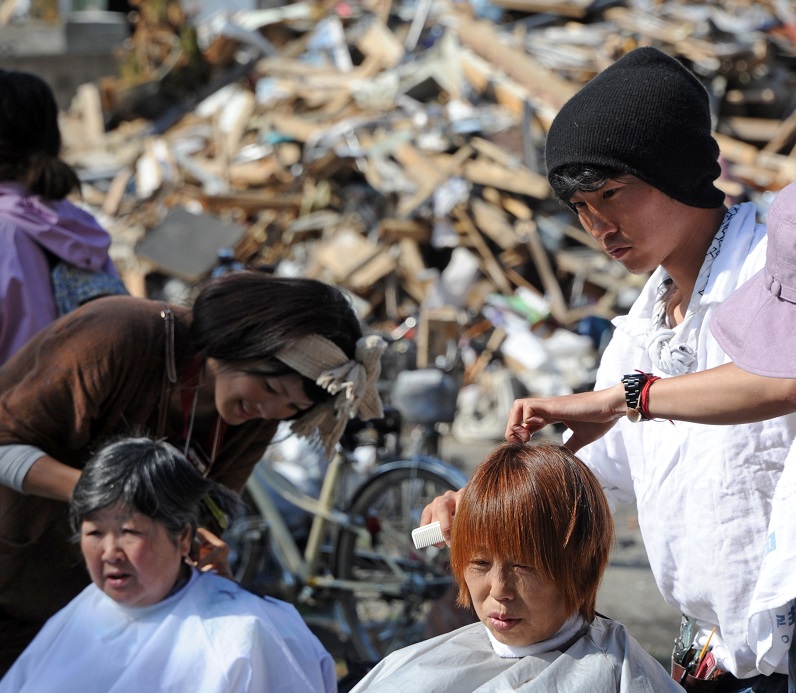 Volunteer beauticians give residents haircuts as people gather for a festival at Omiya shrine to mark Children's Day in the tsunami-devastated city of Ishinomaki, Miyagi prefecture on May 5, 2011. (AFP)