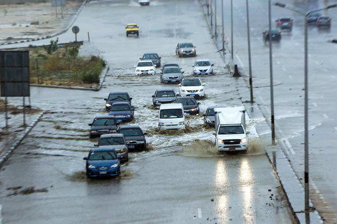 Cars drive along a flooded motorway in the New Cairo suburb of the Egyptian capital on March 12, 2020, amid a heavy rain storm. Two trains were (AFP)