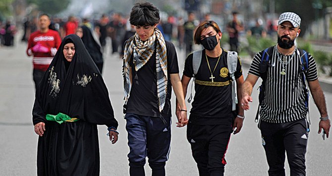 Iraqi pilgrims make their way to a shrine near Baghdad. Fears over coronavirus have hit religious tourism in Iraq, adding to the country’s financial woes. (AFP)