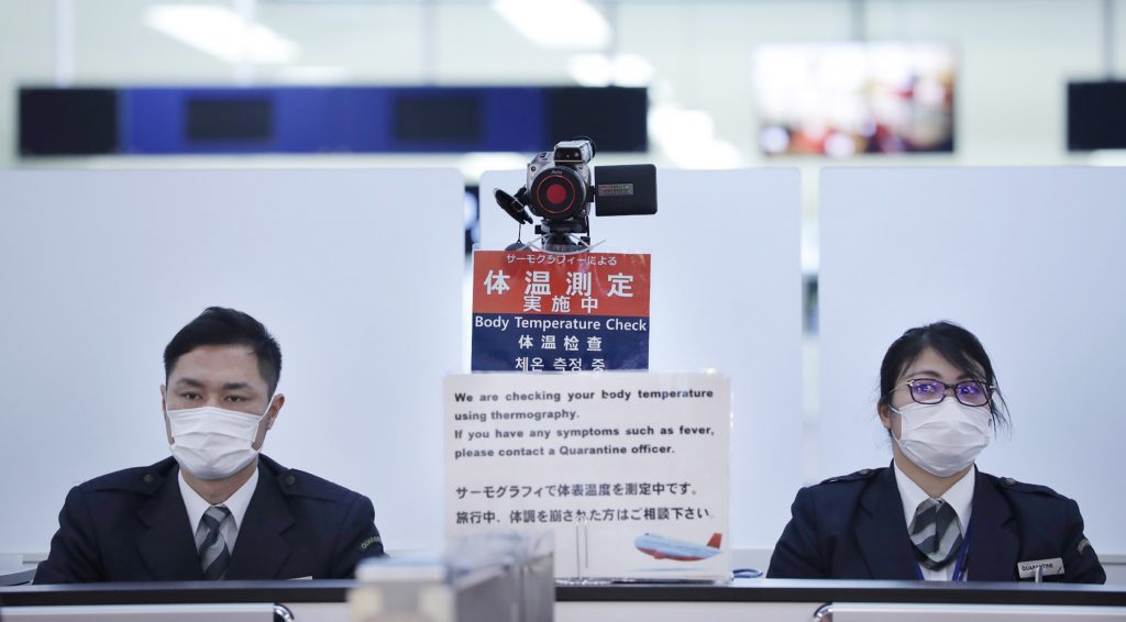 Officers work at a health screening station at Narita Airport, Japan, on January 16, 2020. (AFP)
