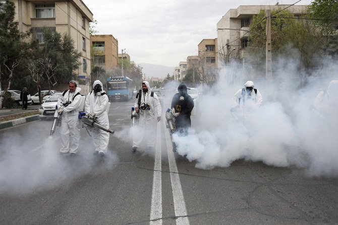 Members of firefighters wear protective face masks, amid fear of coronavirus disease (COVID-19), as they disinfect the streets, ahead of the Iranian New Year Nowruz. (Reuters)