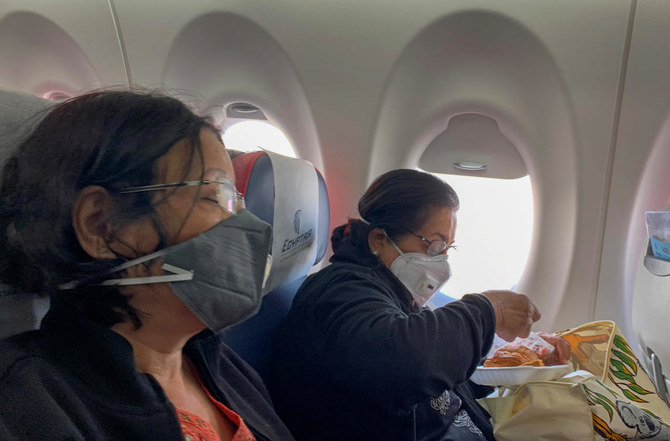 Passengers wear protective masks on an Egyptair flight from Luxor to Cairo, following the outbreak of the coronavirus disease (COVID-19), in Egypt March 10, 2020. (Reuters)