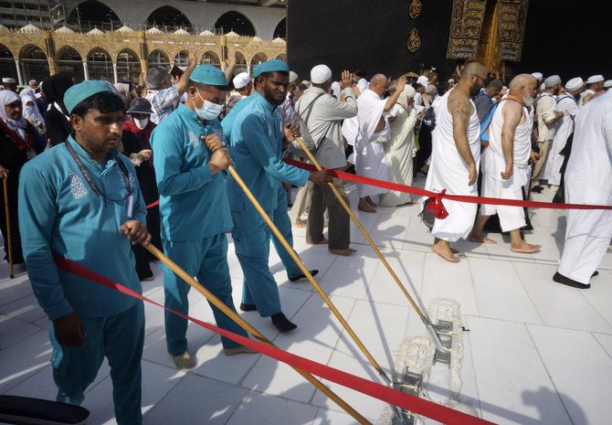 Workers sterilize the ground in front of the Kaaba in the holy city of Makkah, Saudi Arabia, Thursday, Mar. 5, 2020. (AP)