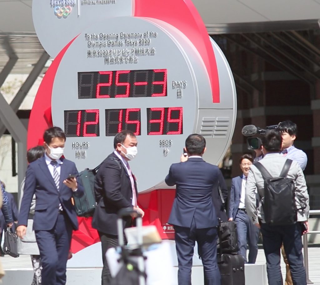 Japanese people with masks on their faces took commemorative photos in front of the red and white clock in the Tokyo Station plaza, located near the Marunouchi district. (AN photo)