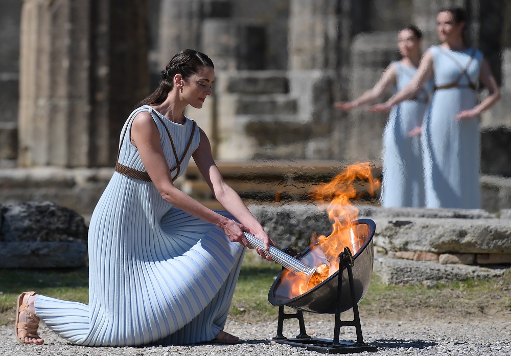 A woman dressed as a priestess lights the Olympic flame during the Olympic ceremony in ancient Olympia, ahead of Tokyo 2020 Olympic Games, on March 12, 2020. (AFP)