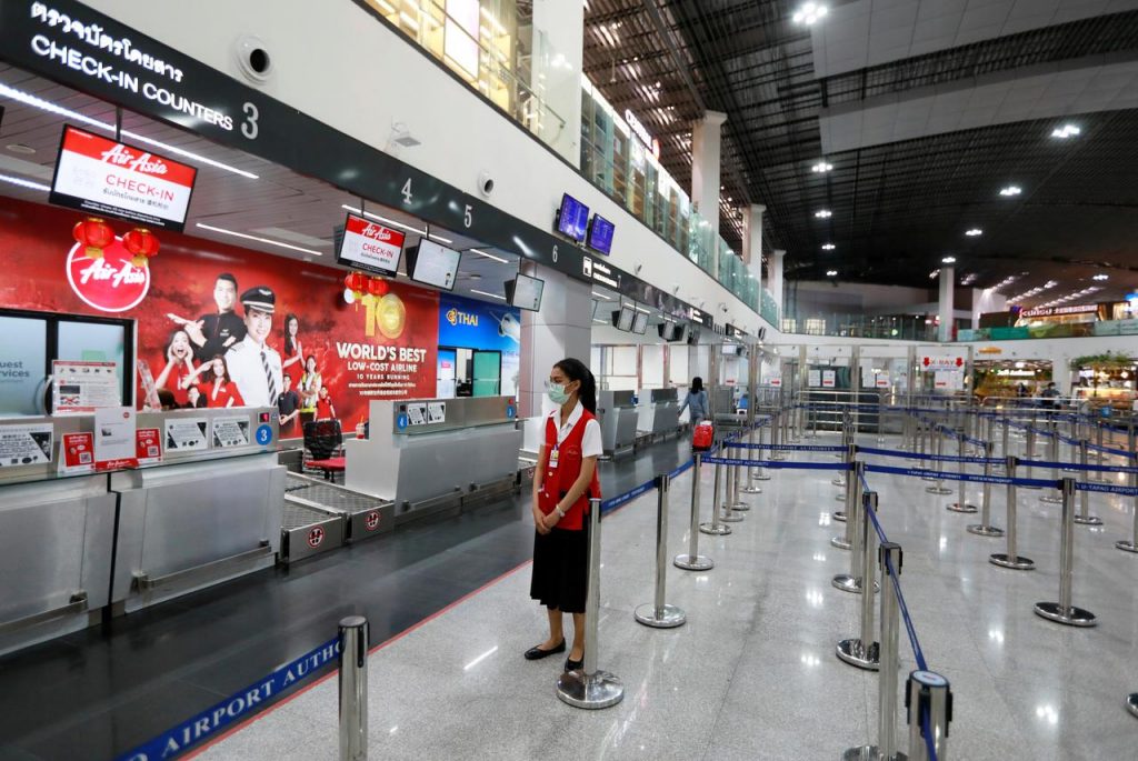 An airline staff member wearing a protective mask stands at U-Tapao Airport, in Rayong, Ban Chang District, Thailand. (Reuters)