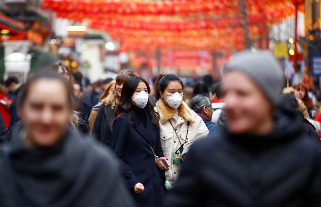 People wear masks as they walk in Chinatown district of London, Britain. (Reuters)