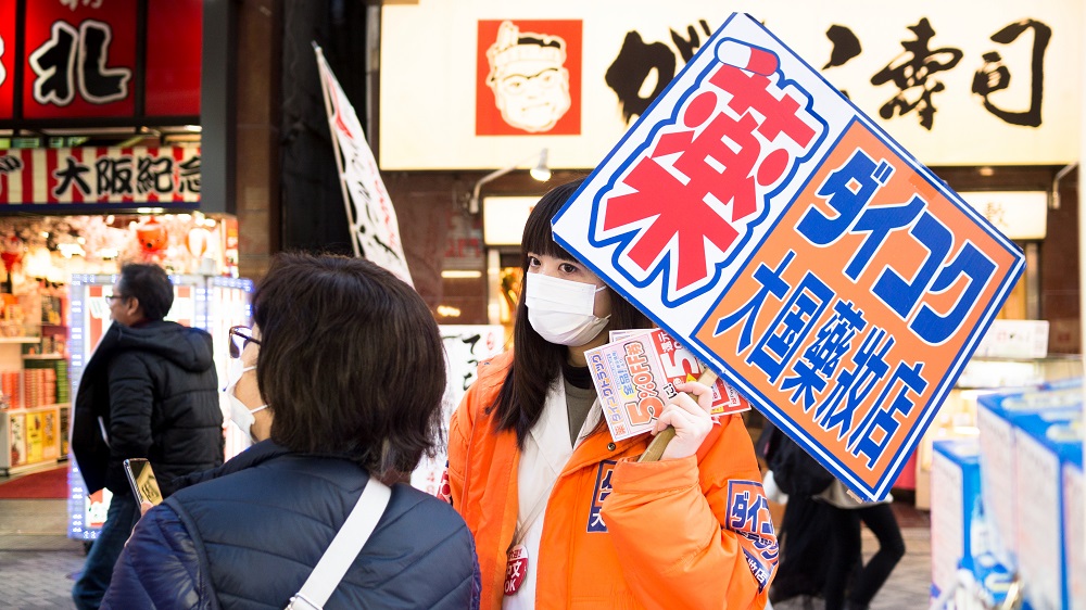 People in the busy Osaka retail street wear face masks during the coronavirus outbreak. (Shutterstock)