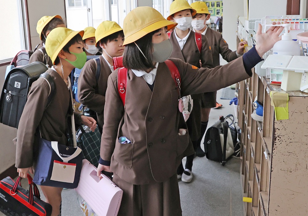 Elementary school children disinfect their hands before leaving school in Osaka on February 28, 2020. (AFP)