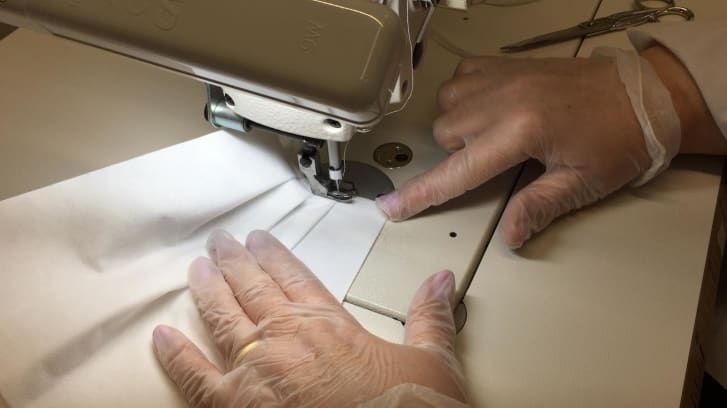 A mask being machine-sewn at a Prada factory in Tuscany, Italy. (Prada)