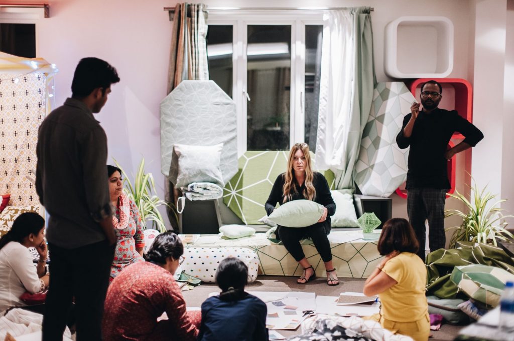 Lebanese designer Nada Debs with Karin Gustavsson, creative leader at IKEA, and a group from the textile supplier sit in a circle on a floor in southern India. (Supplied/Nada Debs)