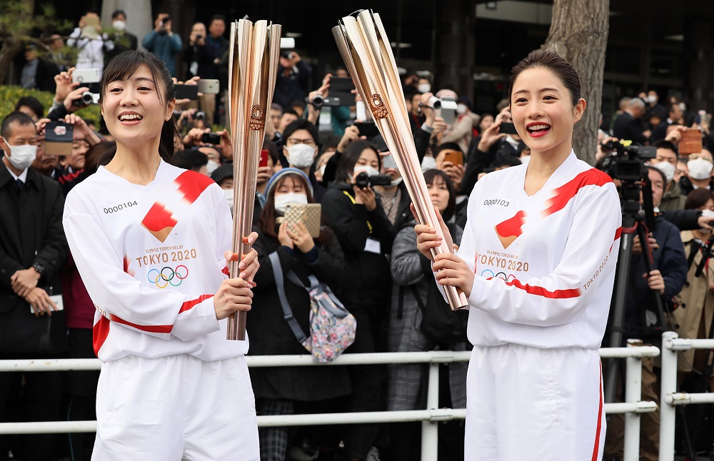 A torchbearer and actress Satomi Ishihara (right), one of the official ambassadors of the Tokyo 2020 torch relay, pose with the Olympic torch during a rehearsal of the Tokyo 2020 Olympics torch relay in Tokyo on February 15, 2020. (AFP)