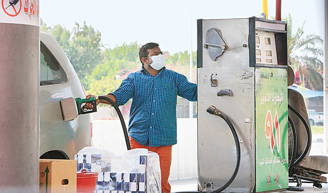 A foreign worker wearing a protective mask fills a car tank at a petrol station in Qatif city in Saudi Arabia’s Eastern Province, some 400km from Riyadh. (AFP)