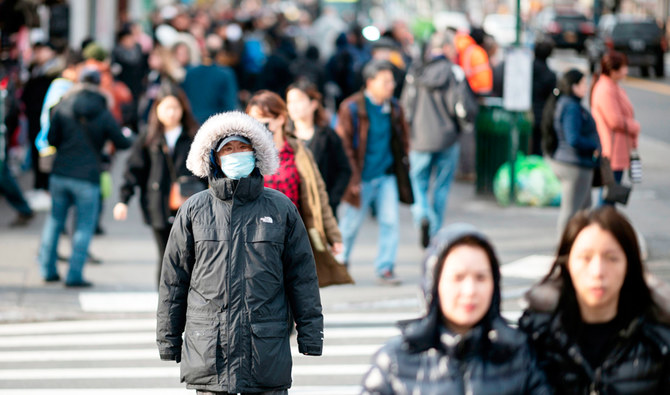People wear face masks as they walk down a street in Flushing area of Queens on March 2, 2020 in New York City. (AFP)