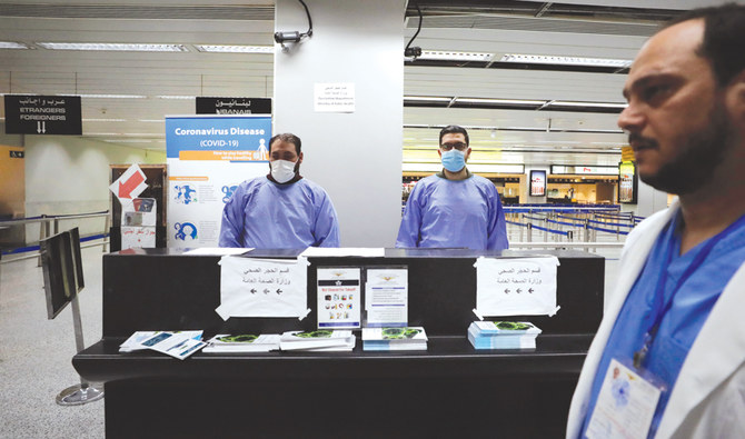 The Lebanese Health Ministry staff wait for passengers to be screened for the coronavirus at the airport in Beirut. (AP)