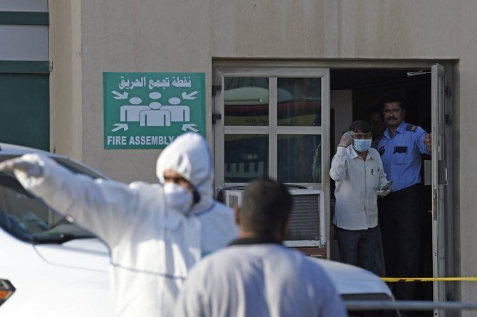 Bahraini policemen seal off a building housing foreign workers in Bahrain’s Salmabad industrial area on March 13, 2020. (AFP)