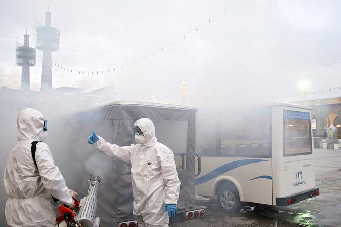 Members of the medical team spray disinfectant to sanitize outdoor place of the Imam Reza shrine in Mashhad, Iran, on Feb. 27, 2020, amid a coronavirus outbreak. WANA (West Asia News Agency) via REUTERS