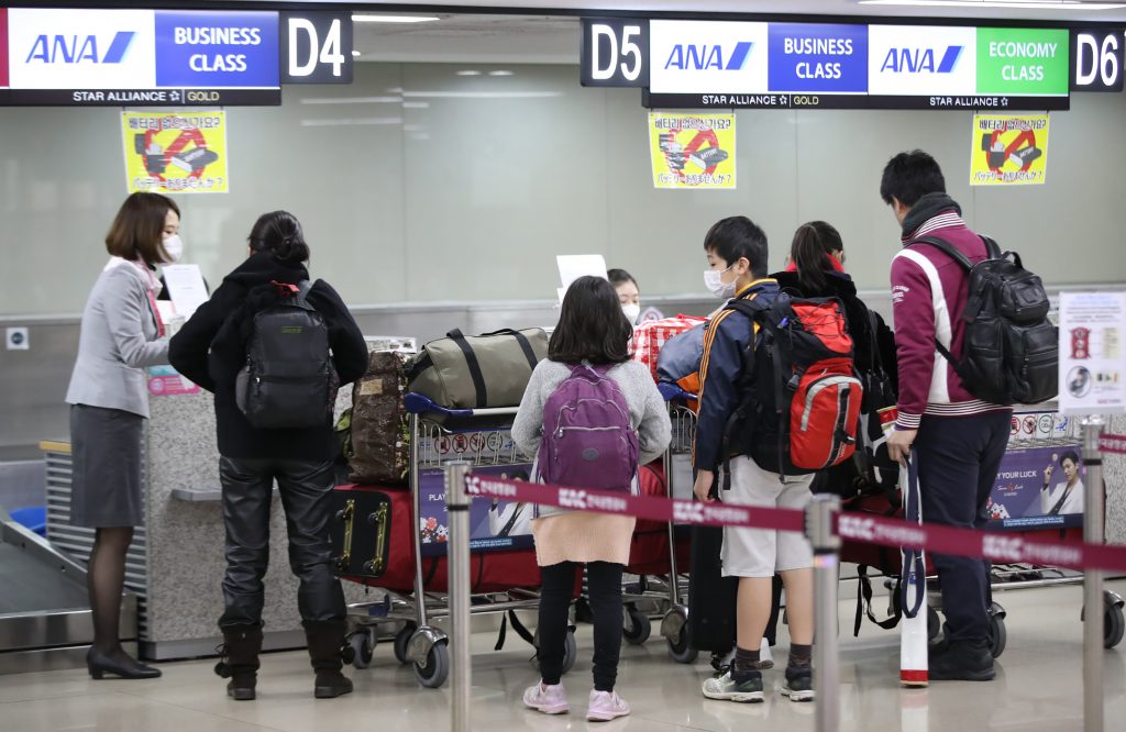 Passengers check in at a Japanese airline desk at Gimpo International Airport in Seoul on March. 6, 2020. (AFP)