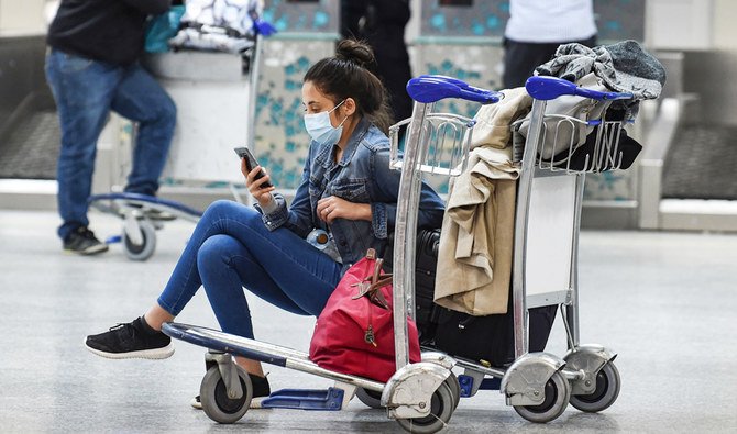 A passenger stranded at Tunis Carthage waits for a flight on March 16, 2020. (AFP)