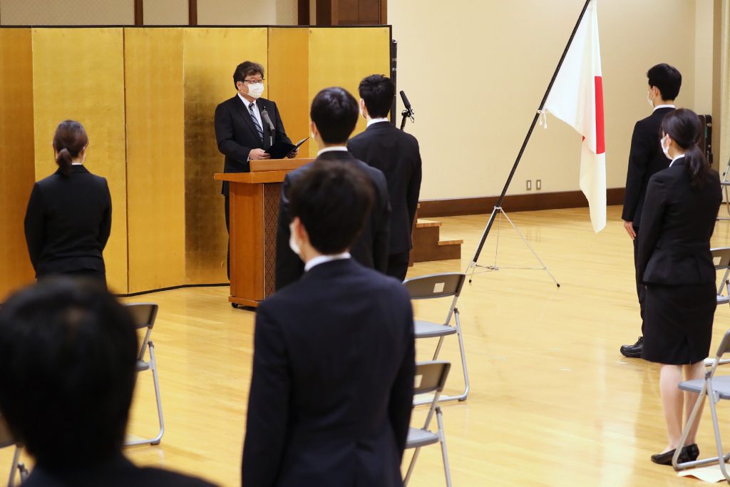 New employees of Japan's education ministry stand apart for social distancing due to concerns over the spread of COVID-19, as they listen to Education Minister Koichi Hagiuda during a ceremony in Tokyo on April. 1, 2020. (AFP)