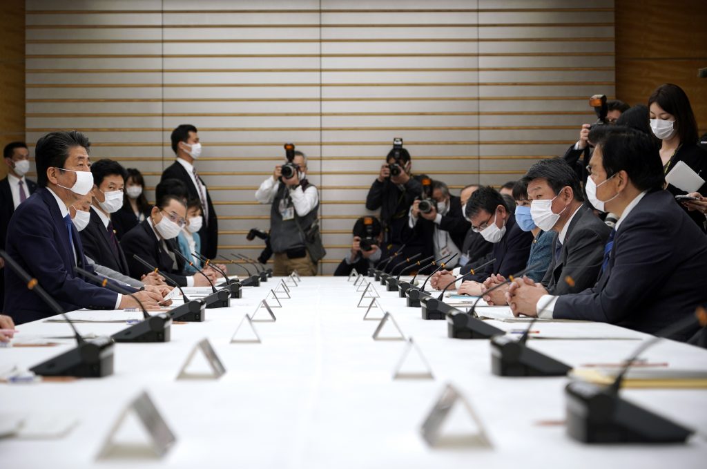 Japan's Prime Minister Shinzo Abe (L) speaks during a meeting at the headquarters for measures against the novel coronavirus disease, at the prime minister's official residence in Tokyo on April. 6, 2020. (AFP)