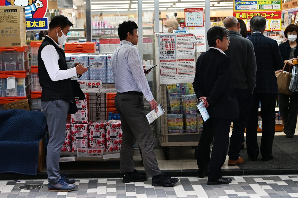 People queue at a drugstore to pay for their face masks amid concerns of the COVID-19 coronavirus in Tokyo on April. 22, 2020. (AFP)