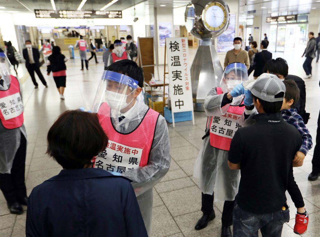 Aichi prefectural government employees wearing face masks or face shields started on the day to ask travelers to have their temperatures checked on a voluntary basis. (AFP)
