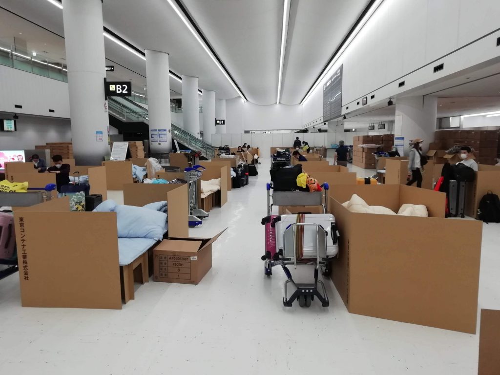 In this April 8, 2020 photo provided by Naohiro Katsuta, people wait their test results for the coronavirus at temporary beds made with cardboard boxes at Narita International Airport in Narita, near Tokyo. (AP)