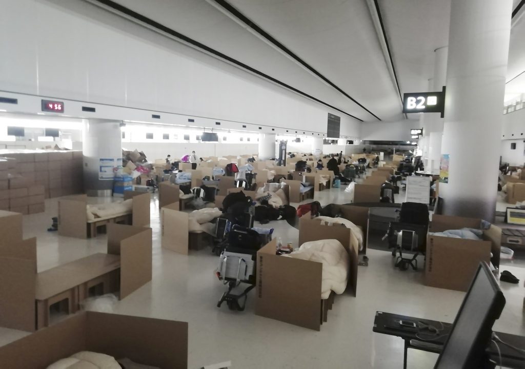 In this April 8, 2020 photo provided by Naohiro Katsuta, people wait their test results for the coronavirus at temporary beds made with cardboard boxes at Narita International Airport in Narita, near Tokyo. (AP)