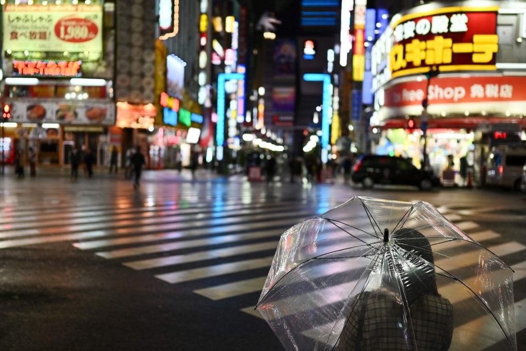 People wait to cross a street on Saturday night in almost empty Tokyo's Shinjuku area on April 11, 2020. (AFP)
