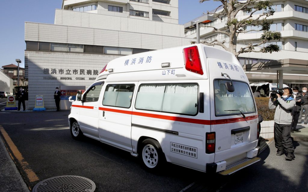 In this Feb. 5, 2020, photo, an ambulance carrying a passenger onboard cruise ship Diamond Princess arrives at a hospital in Yokohama, near Tokyo. Hospitals in Japan are increasingly turning away sick people in ambulances as the country braces for a surge in coronavirus infections. The Japanese Association for Acute Medicine and the Japanese Society for Emergency Medicine say emergency medicine has already collapsed with many hospitals refusing to treat people including those suffering strokes, heart attacks and external injuries. (Kyodo News via AP)