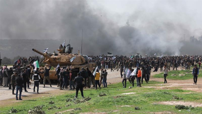 Protesters display Syrian opposition flags during a demonstration against joint Russian and Turkish patrols in Idlib on March 15, 2020. (Reuters)