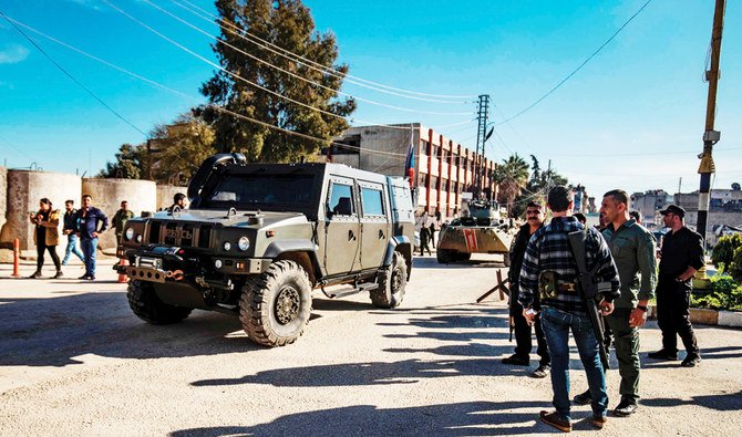 The pro-Assad Russian military patrol a street in the Kurdish-majority city of Qamishli, in Syria’s northeastern Hasakah province on Saturday. (AFP)