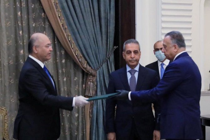 Iraq’s President Barham Salih, left, instructs newly appointed Prime Minister Mustafa Al-Kadhimi in Baghdad on April 9, 2020. (The Presidency of the Republic of Iraq Office via Reuters)