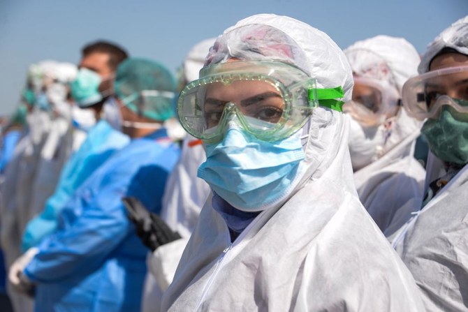Iraqi medical personnel gather in a show of support for healthcare workers and patients during the coronavirus (COVID-19) pandemic, in the northern Iraqi city of Mosul on April 14, 2020. (AFP)