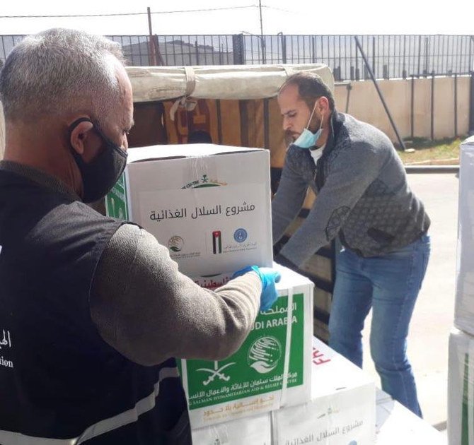 KS Relief workers handing over food aid in Yemen. (SPA)