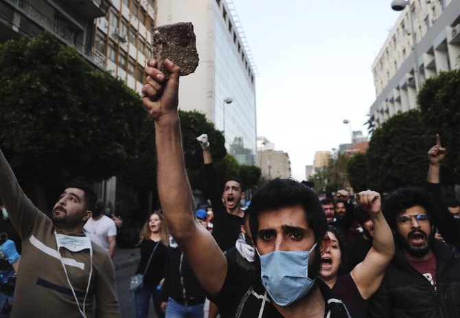 Anti-government protesters, some wearing masks to help curb the spread of the coronavirus, shout slogans as they march during a protest against the Lebanese central bank's governor Riad Salameh and against the deepening financial crisis, at Hamra trade street, in Beirut, Lebanon, Thursday, April 23, 2020. (AP)