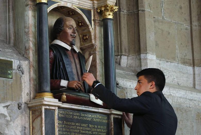 A symbolic quill is placed in the hand of a statue of William Shakespeare, marking the 450th anniversary of his birth inside Holy Trinity Church in Stratford-upon-Avon, April 26, 2014. (Reuters)