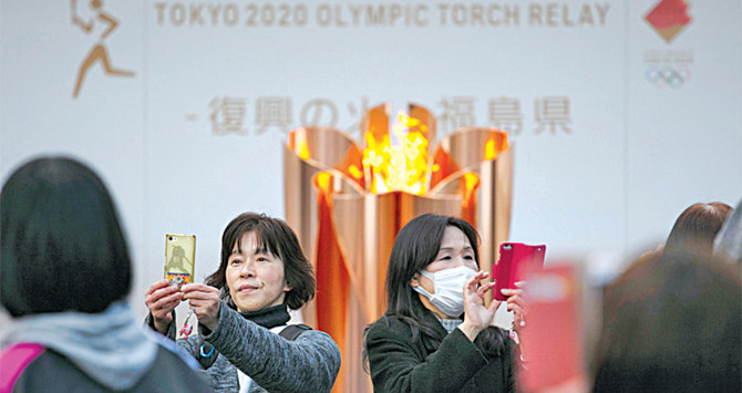 People take pictures with the Olympic Flame in Fukushima City, Japan. (Files/AP)