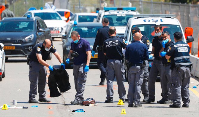 Israeli police secure the scene of an attack in Kfar Saba on Tuesday. A Palestinian teenager stabbed an Israeli woman before he was shot by a security guard. (AFP)