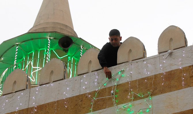 A man hangs decorations ahead of the Muslim holy month of Ramadan on a mosque during a countrywide lockdown over the coronavirus disease (COVID-19) in Beirut, Lebanon April 17, 2020. (Reuters)