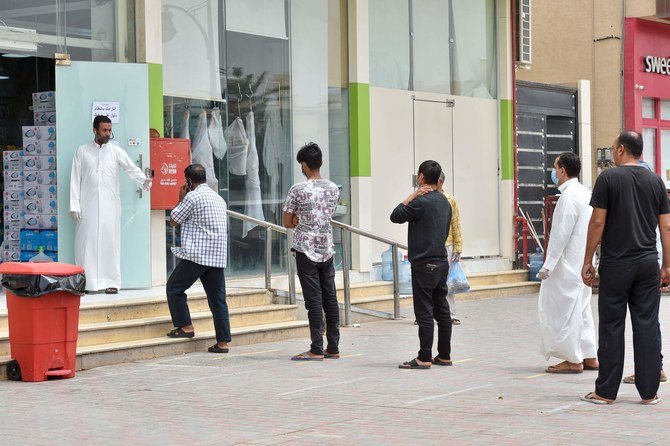 Customers queue outside a supermarket while maintaining social distancing during a nationwide curfew to stem the spread of COVID-19 in the Saudi capital Riyadh on April 13, 2020. (AFP)