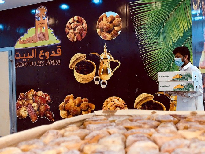 A Saudi seller wearing a protective face mask holds boxes of dates at his shop, during the 24-hours lockdown to counter the coronavirus disease (COVID-19) outbreak, ahead of the holy fasting month of Ramadan, in Riyadh, Saudi Arabia April 20, 2020. Picture taken April 20, 2020. (Reuters)