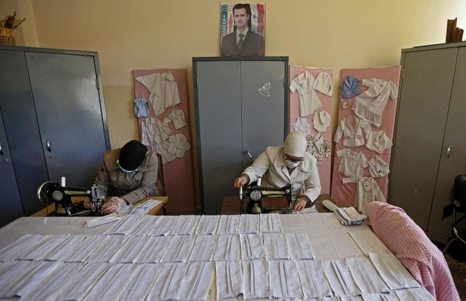 Syrian teachers make face masks in an educational institute in the capital Damascus, on April 26, 2020, amid the novel coronavirus pandemic crisis. (AFP)