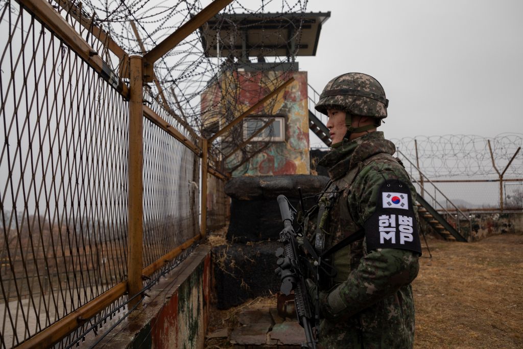 A South Korean soldier stands before a security fence at a guard post inside the Demilitarized Zone (DMZ) near the Military Demarcation Line (MDL) separating North and South Korea, Dec. 3, 2018. (AFP)
